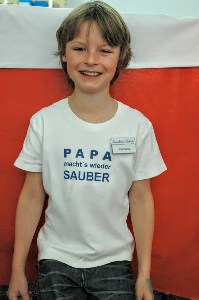Julian Schulz (heute Jahnke) als Kind im T-Shirt mit der Aufschrift „PAPA macht's wieder SAUBER“ beim Eröffnungsfest