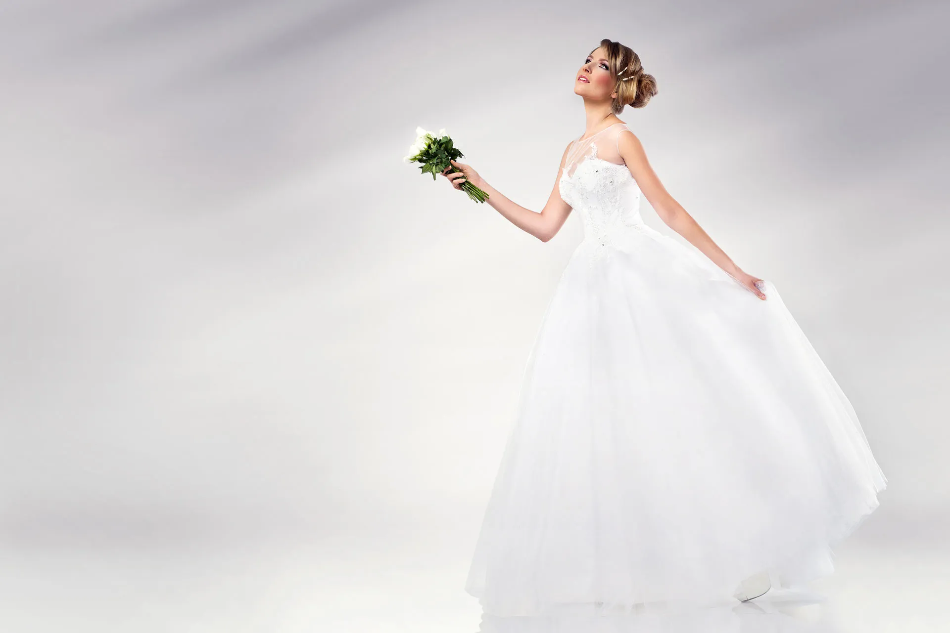 Braut im weißen Hochzeitskleid mit Blumenstrauß